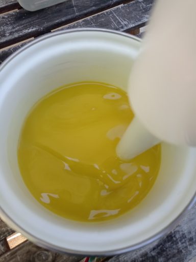 Eine gelbe Flüssigkeit in einer Schüssel, mit einem Stabmixer darin.